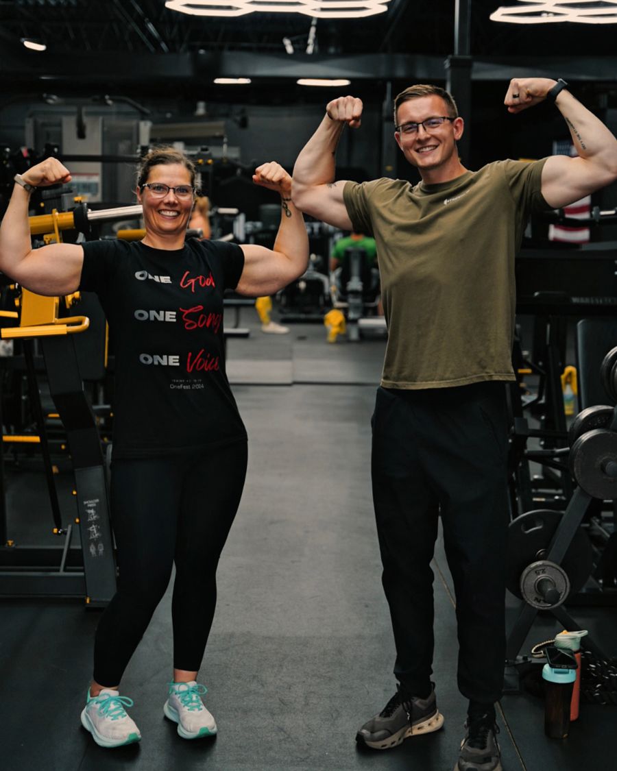 Client and coach flexing together in the Calibrated Strength gym